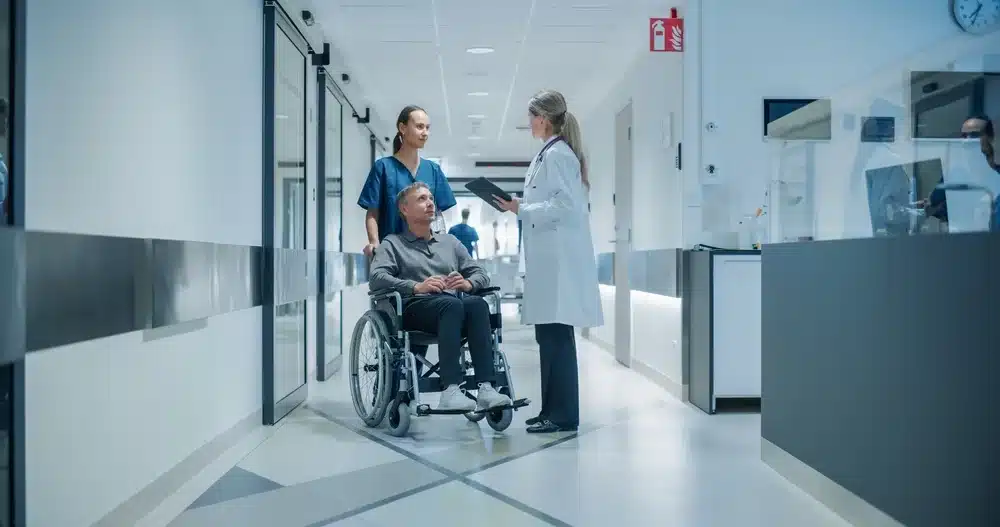 Female physician approaching a man in a wheelchair in healthcare environment