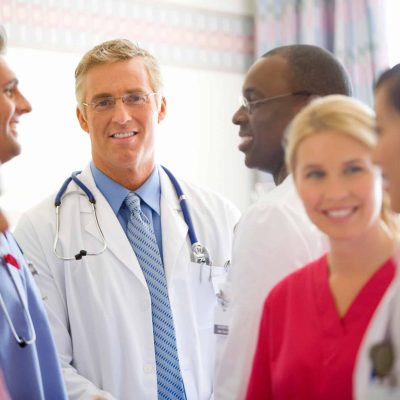a group of hospital workers talking and smiling
