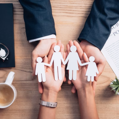 top view of lawyer and woman holding paper cut family near cup of coffee, insurance policy